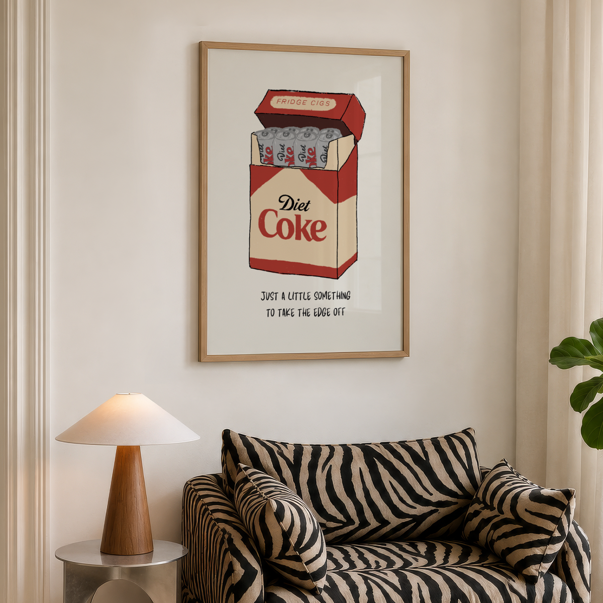 A framed vintage-style Diet Coke poster hangs on a cream wall above a zebra-print armchair in a styled living room with a side table, lamp, and potted plant.