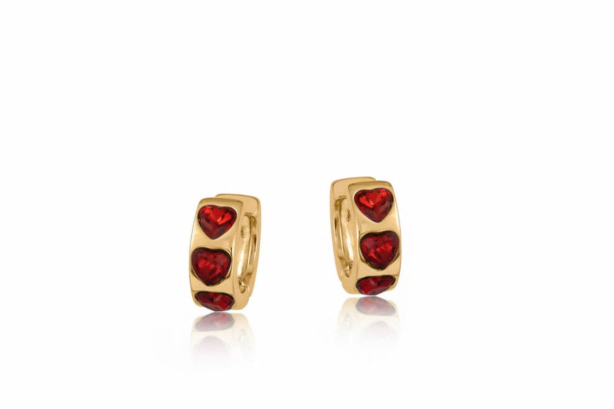 Gold hoop earrings with red heart stones on a white background